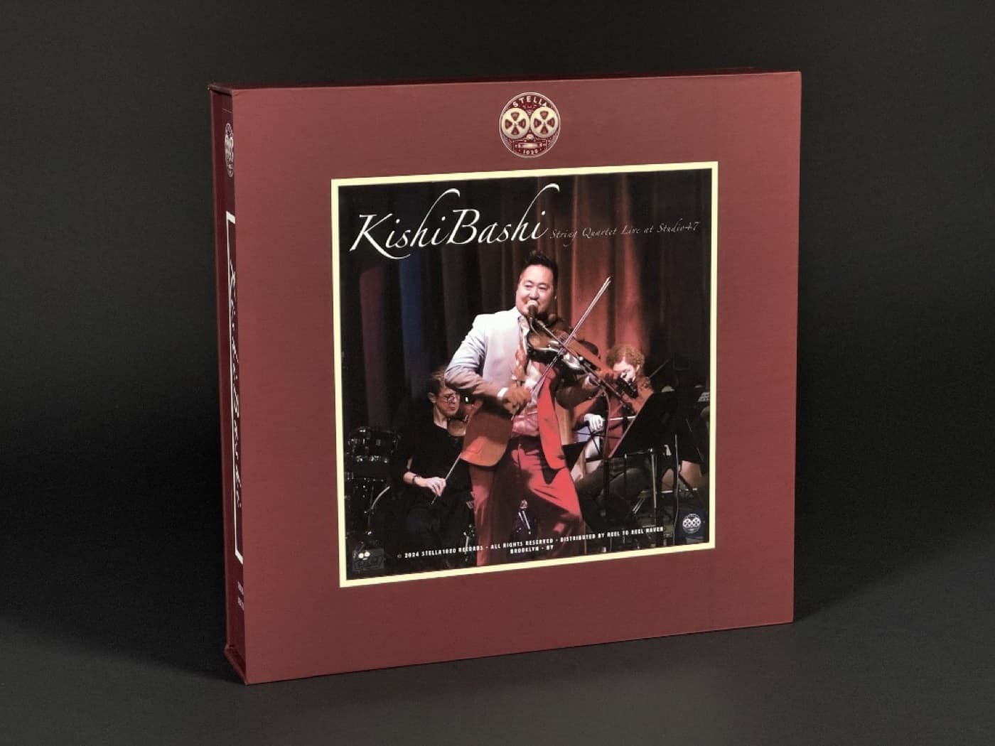Close-up of Kishi Bashi album box showing him performing with violin and string quartet