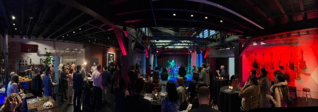 Musicians performing in industrial studio space with red curtains and professional lighting