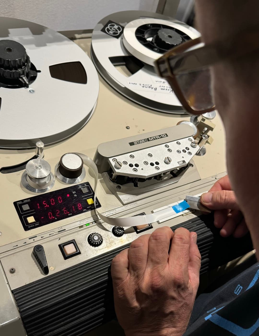 Close-up of Otari MTR-10 professional tape machine with hands adjusting tape